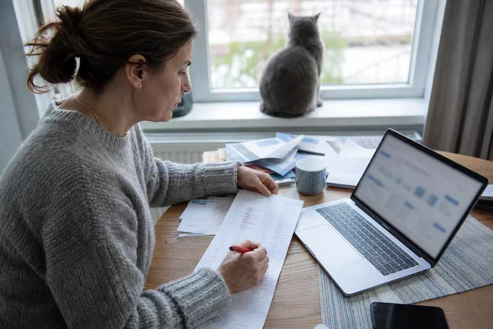 Portfolio owner deciding which names to renew with a laptop and paper list
