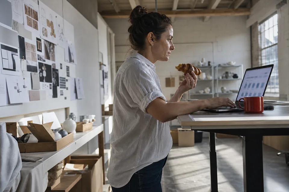 Founder at a standing desk reviewing a domain deal on her laptop in morning light
